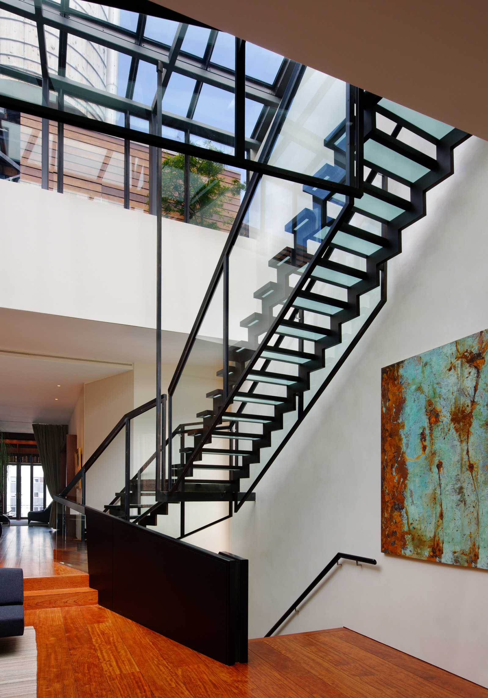 Glass and steel stairs to roof deck, with large skylight.