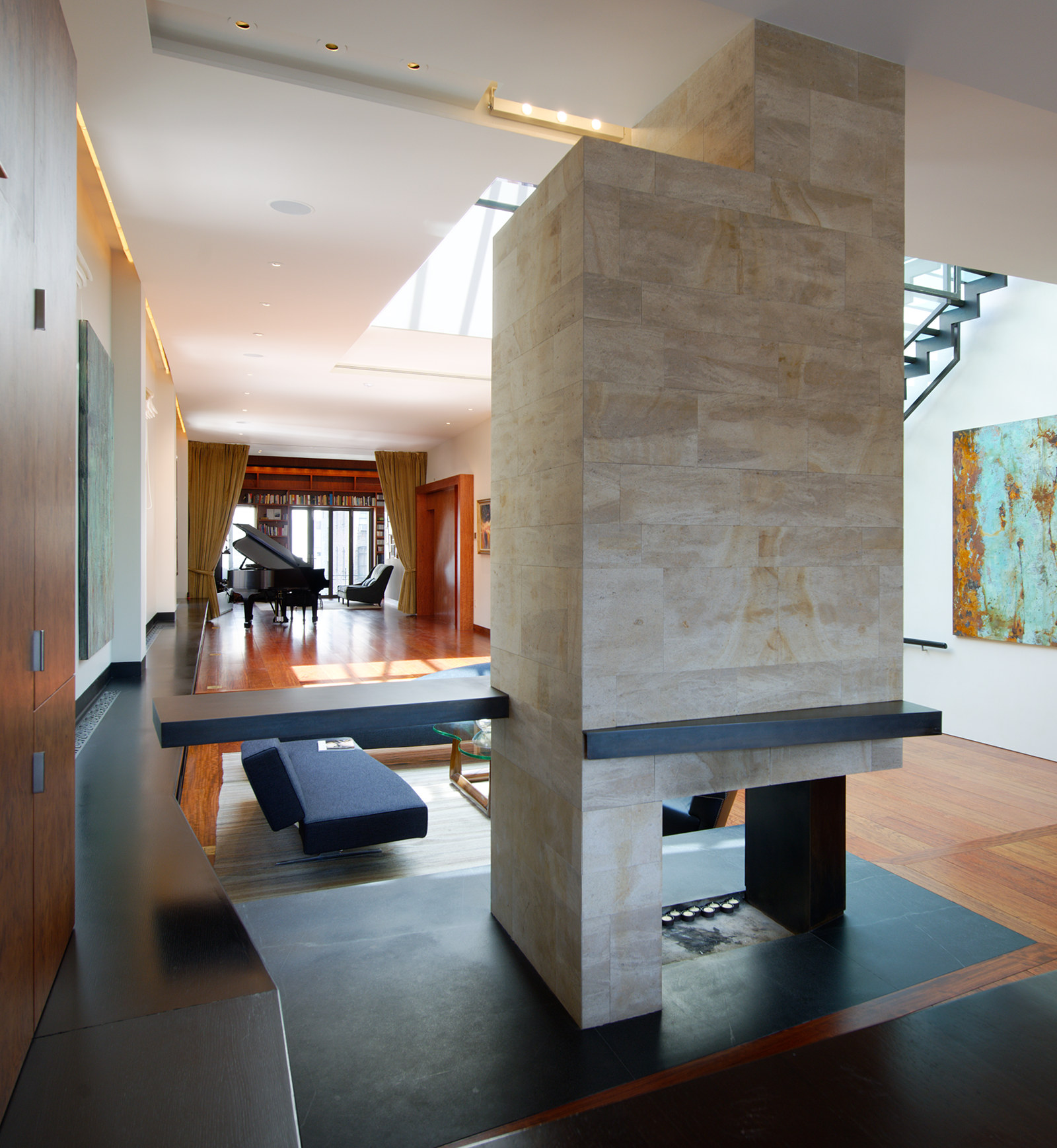 Modern stone-clad fireplace, open on 2 sides, with steel accents.