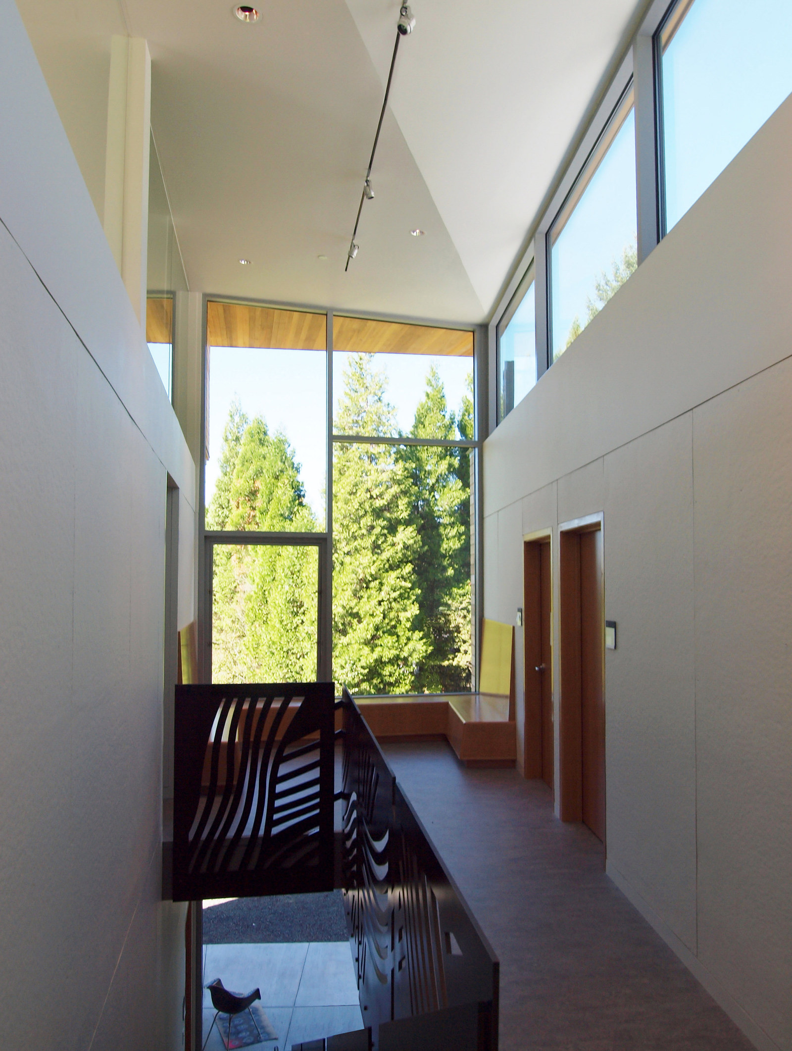 Light-filled corridor, large windows, clerestory windows, custom steel guardrail designed by Linda Hutchins