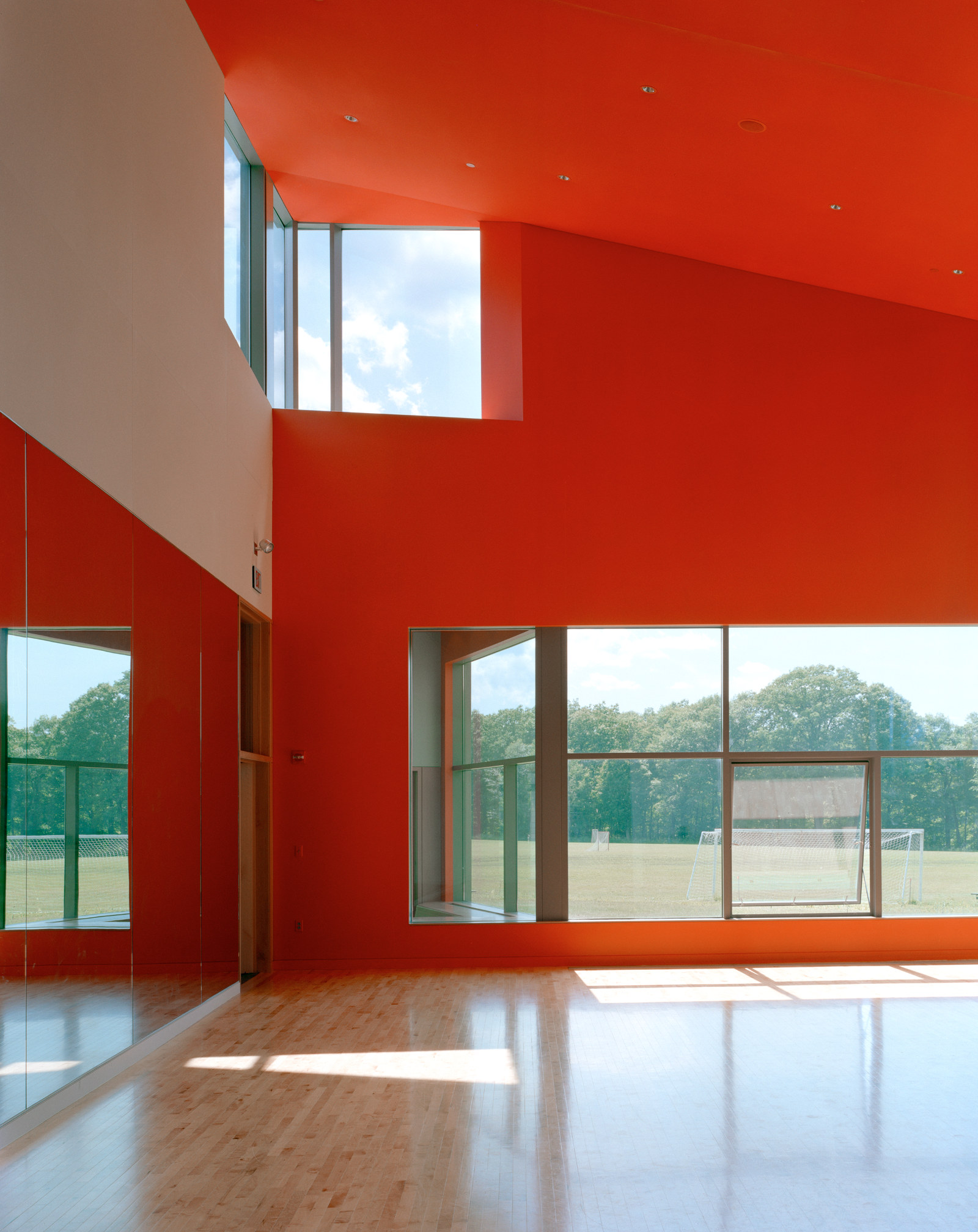 Light-filled dance studio with red walls, at The Putney School.