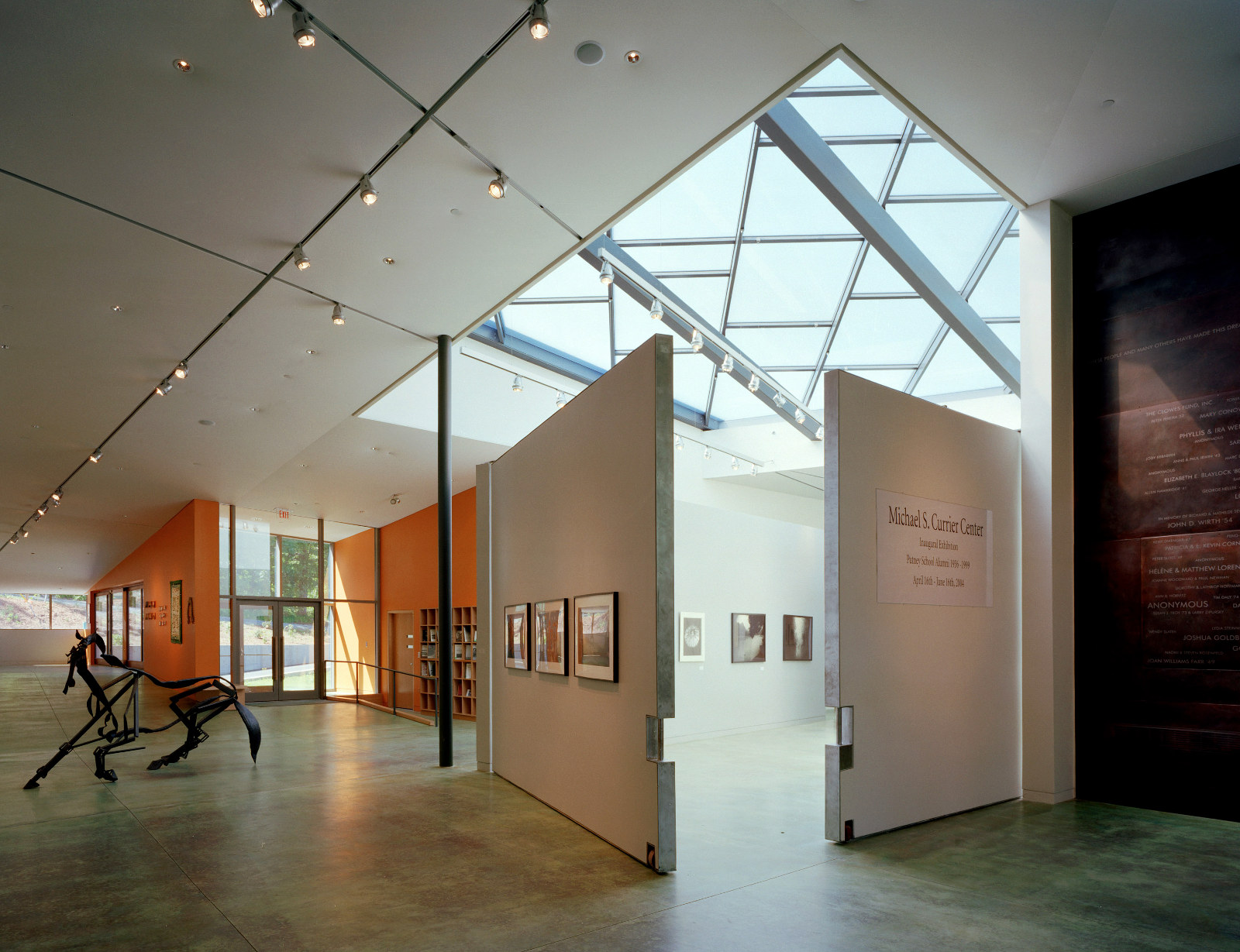 Light-filled corridor and gallery space at The Putney School, with skylights and green-stained concrete floor.