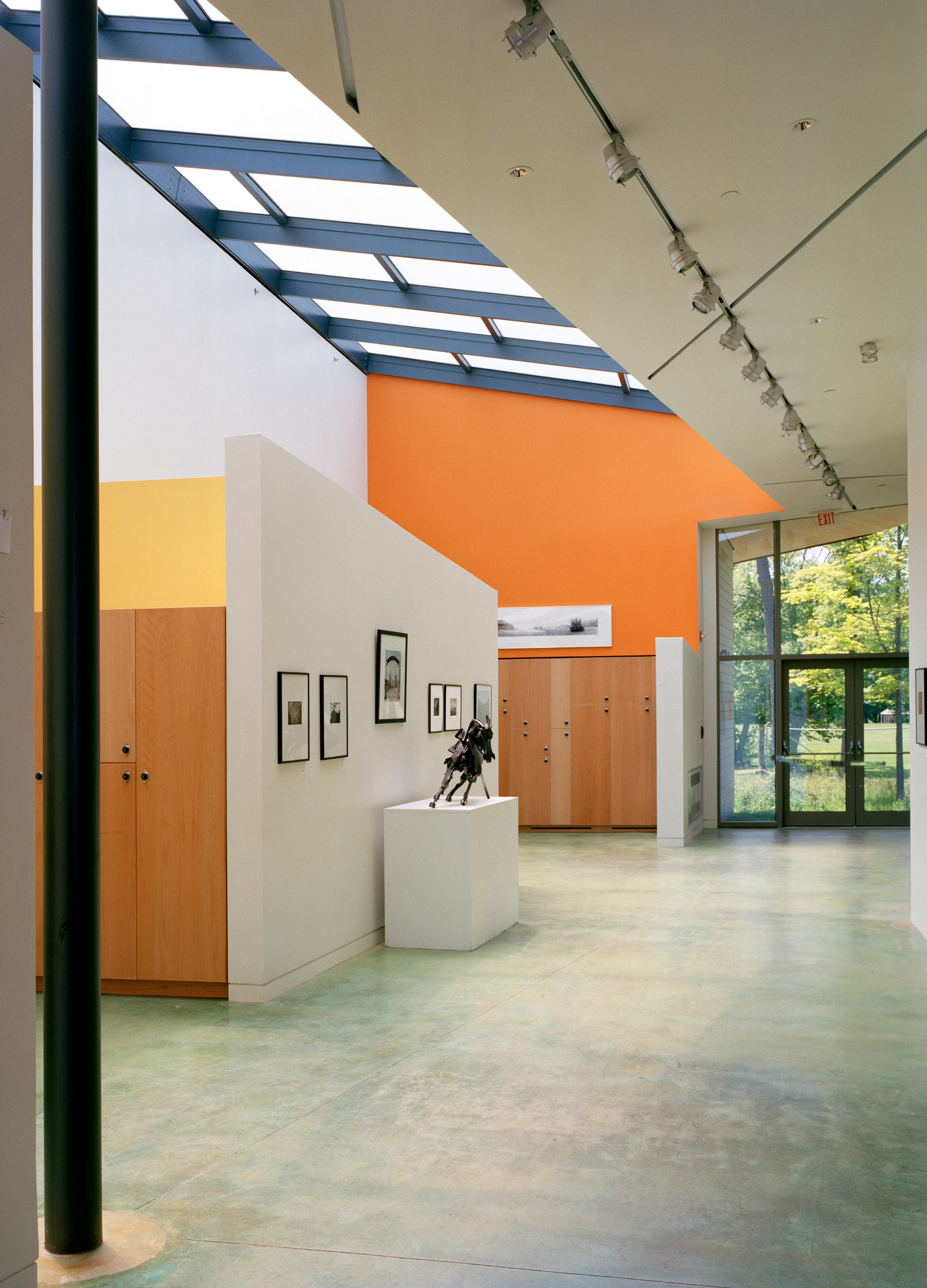 Light-filled corridor and gallery space at The Putney School, with skylights and green-stained concrete floor.
